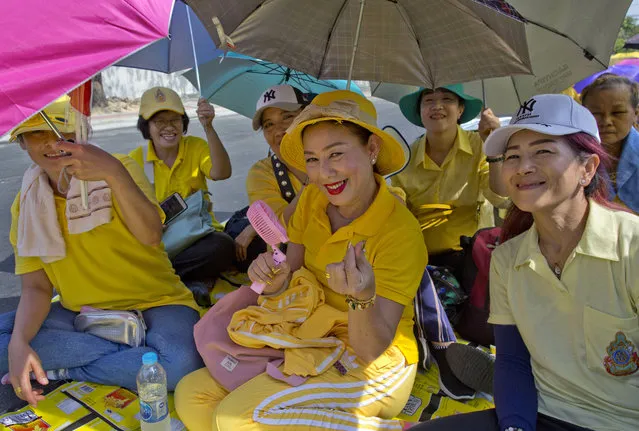 Thai people sit on a side-road, anticipating access to Suddhaisavarya Prasad Hall, in which Thailand's King Maha Vajiralongkorn scheduled to grant a public audience in Bangkok, Thailand, Monday, May 6, 2019. King Maha Vajiralongkorn was officially crowned amid the splendor of the country's Grand Palace, taking the central role in an elaborate centuries-old royal ceremony that was last held almost seven decades ago. (Photo by Gemunu Amarasinghe/AP Photo)