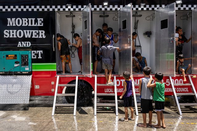 Children use a mobile shower provided by the local government, amid extreme heat in Valenzuela, Metro Manila, Philippines, on May 2, 2024. (Photo by Eloisa Lopez/Reuters)