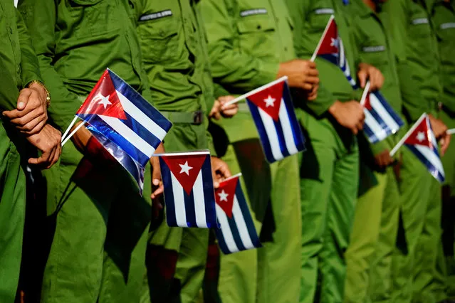 Army soldiers hold Cuban flags as they mark the 60th anniversary of the killing of Cuban revolutionary and student leader Jose Antonio Echeverria in Havana, Cuba, March 13, 2017. (Photo by Alexandre Meneghini/Reuters)