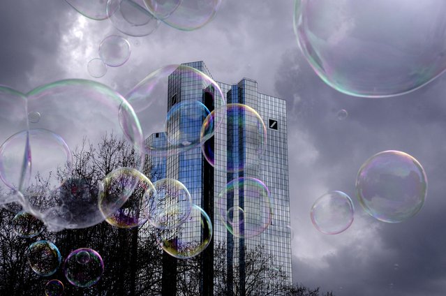 Bubbles made by a soap bubble artist, fly in front of the headquarters of Deutsche Bank in Frankfurt, Germany, Friday, March 24, 2023. (Photo by Michael Probst/AP Photo)