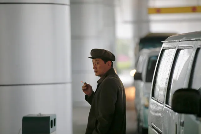 A man smokes a cigarette outside the airport in Pyongyang, North Korea May 3, 2016. (Photo by Damir Sagolj/Reuters)