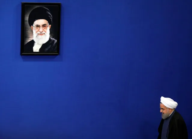Iranian President Hassan Rouhani (R) arrives, next to the picture of Iranian supreme leader Ali Khamenei, for a press conference in Tehran, Iran, 10 April 2017. Media reported that Rouhani said that US chemical excuse for attacking to Syria was not proved, and US did not act in framework of international regulations. (Photo by Abedin Taherkenareh/EPA)