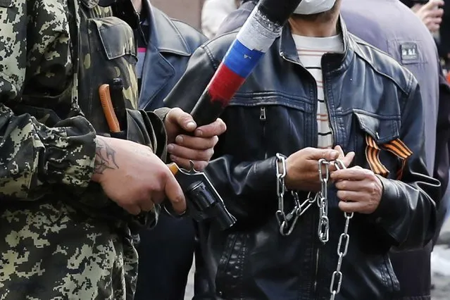 Armed pro-Russian activists look on during clashes with supporters of the Kiev government in the streets of Odessa May 2, 2014. (Photo by Yevgeny Volokin/Reuters)