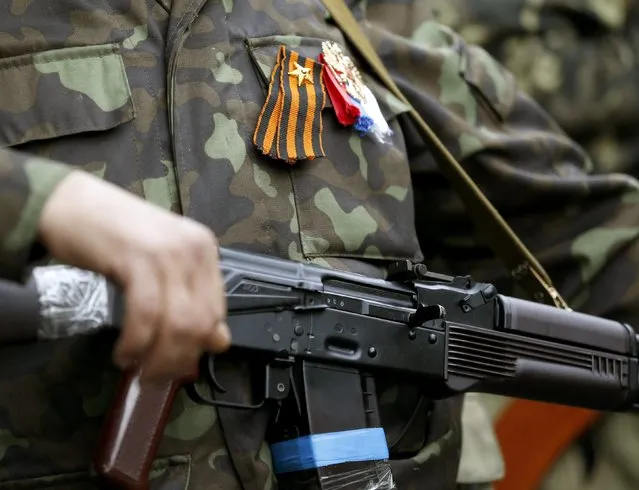 An armed pro-Russian activist holds his weapon as he stands near the seized regional government headquarters in Luhansk, eastern Ukraine, May 3, 2014. (Photo by Vasily Fedosenko/Reuters)
