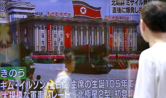 A man watches a TV news showing footage of Saturday's military parade in Pyongyang while reporting North Korea's rocket launch, in Tokyo, Sunday, April 16, 2017. A North Korean missile exploded during launch Sunday from the country's east coast, U.S. and South Korean officials said, a high-profile failure that comes as a powerful U.S. aircraft carrier approaches the Korean Peninsula in a show of force. The letters on the top read “North Korea's missile might have exploded and failed soon after launch”. (Photo by Shizuo Kambayashi/AP Photo)