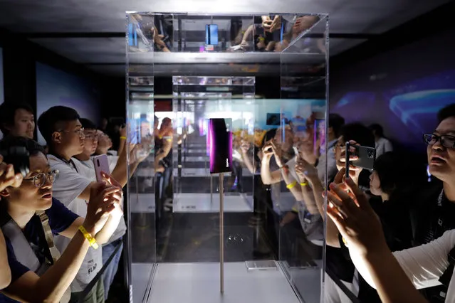 Visitors look at Xiaomi MIX Alpha smartphones after the Xiaomi new 5G smartphone product launch ceremony in Beijing, China, 24 September 2019. Xiaomi releases its new mobile phone products “Mi 9 Pro 5G” and “Xiaomi MIX Alpha” on 24 September 2019. (Photo by Wu Hong/EPA/EFE)