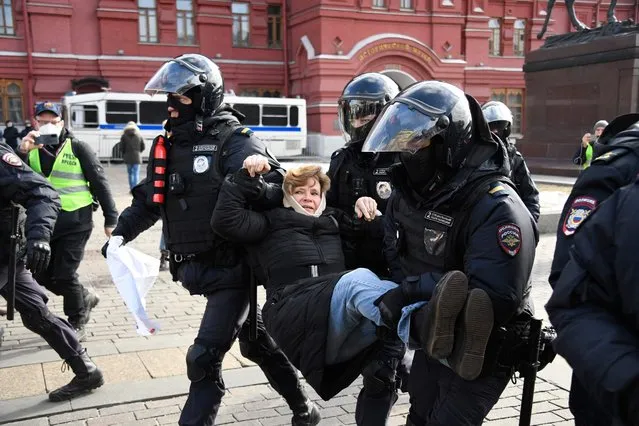 Police officers detain a woman during a protest against Russian military action in Ukraine, in Manezhnaya Square in central Moscow on March 13, 2022. (Photo by AFP Photo/Stringer)