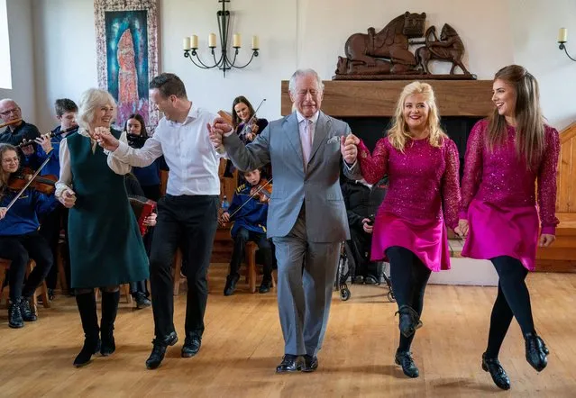 Britain's Prince Charles and Camilla, Duchess of Cornwall join in with the dancers during their visit at the Bru Boru Cultural Centre in Cashel, County Tipperary, Ireland on March 25, 2022. (Photo by Arthur Edwards/Pool via Reuters)