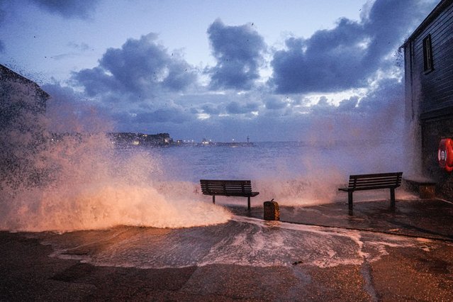 Waves crash over the harbour wall onto the street in the early morning on April 09, 2024 in St Ives, Cornwall, England. On Monday, the Met Office issued severe weather warnings for wind across the southern and western coasts of England and Wales, effective until Tuesday afternoon. This follows the turbulent weather over the weekend, when Storm Kathleen, combined with high tides, generated massive waves along the Cornish coast. (Photo by Hugh Hastings/Getty Images)