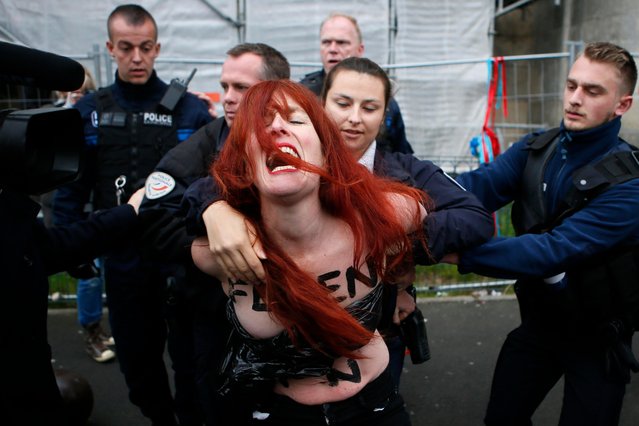 A Femen activist is led away by French police in Henin-beaumont, northern France, Sunday, May 7, 2017. Voters across France are choosing a new president in an unusually tense and important election that could decide Europe's future, making a stark choice between pro-business progressive candidate Emmanuel Macron and far-right populist Marine Le Pen. (Photo by Francois Mori/AP Photo)