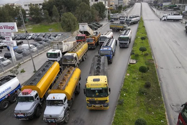 Tanker trucks block a main highway during a general strike by public transport and labor unions to protest the country's deteriorating economic and financial conditions in Beirut, Lebanon, Thursday, January 13, 2022. Protesters closed the country's major highways as well as roads inside cities and towns starting 5 a.m. making it difficult for people to move around. (Photo by Hussein Malla/AP Photo)