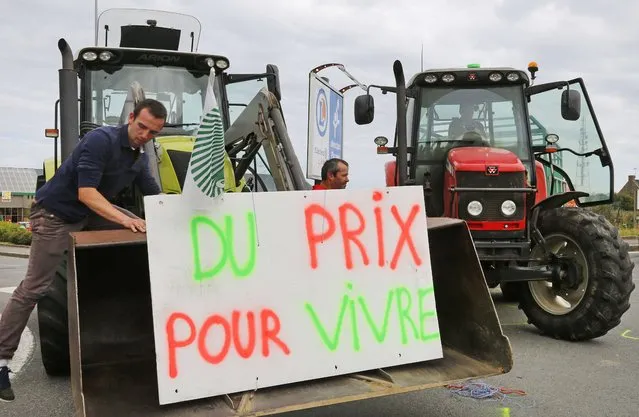Livestock breeders block the entrance of a commercial center in Saint-Malo in the northwestern region of Brittany, France, to protest against a squeeze in margins by retailers and food processors, July 22, 2015. (Photo by Jacky Naegelen/Reuters)