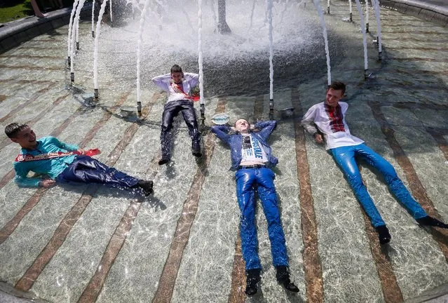 Ukrainian students fool around in a fountain as they celebrate the end of their school term on Independence Square in downtown Kiev, Ukraine, 27 May 2016. (Photo by Roman Pilipey/EPA)
