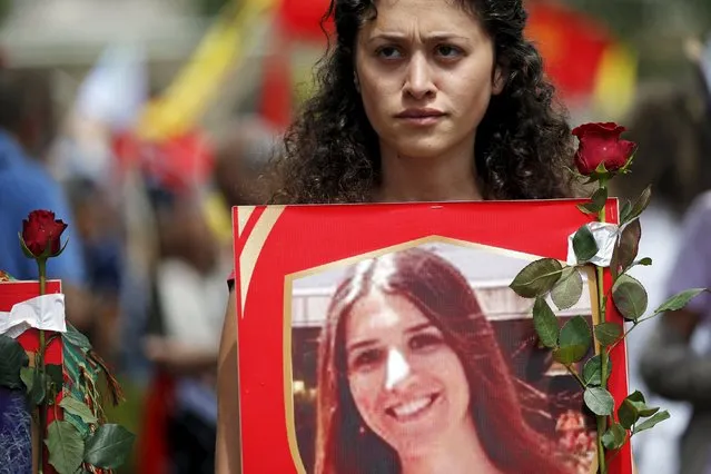 A member of the Kurdish community in France holds a poster depicting a victim of Monday's bomb attack in Suruc, Turkey, during a demonstration to condemn the attack, in Paris, France, July 25, 2015. (Photo by Stephane Mahe/Reuters)