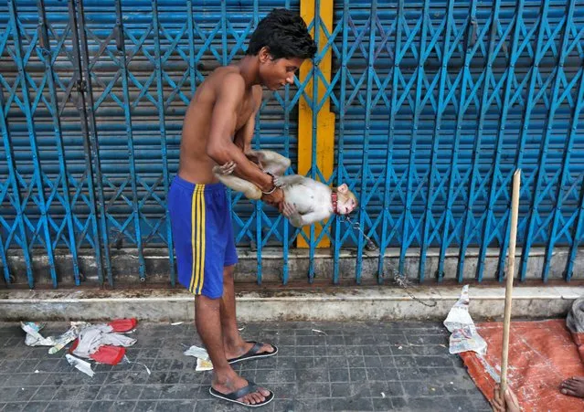A man plays with his pet monkey Rani outside closed shops on a pavement in Kolkata, India May 30, 2016. (Photo by Rupak De Chowdhuri/Reuters)