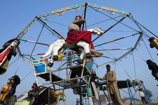 Children ride a mary-go-round in Lahore, Pakistan on December 5, 2019. (Photo by Arif Ali/AFP Photo)