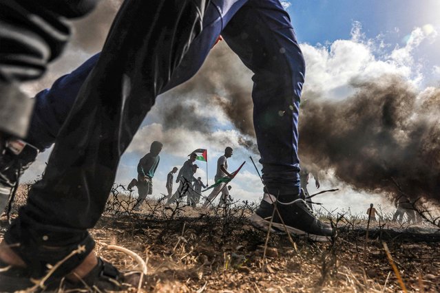 Protesters gather for their own Palestinian “flag march” demonstration along the border with Israel east of Gaza city on May 18, 2023 in response to the annual Israeli flag march marking “Jerusalem Day” commemorating the old city's capture by Israel. (Photo by Mohammed Abed/AFP Photo)