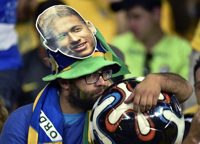 A Brazil supporter reacts during the World Cup semifinal soccer match between Brazil and Germany at the Mineirao Stadium in Belo Horizonte, Brazil, Tuesday, July 8, 2014. (Photo by Martin Meissner/AP Photo)