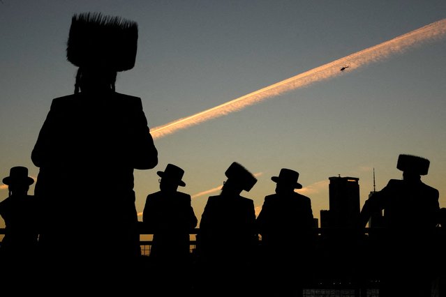 Ultra-Orthodox Jewish people perform the Tashlich ritual of symbolically casting away their sins during Rosh Hashanah, ahead of Yom Kippur the Jewish Day of Atonement, by the East River in New York City, U.S., October 3, 2024. (Photo by Adam Gray/Reuters)