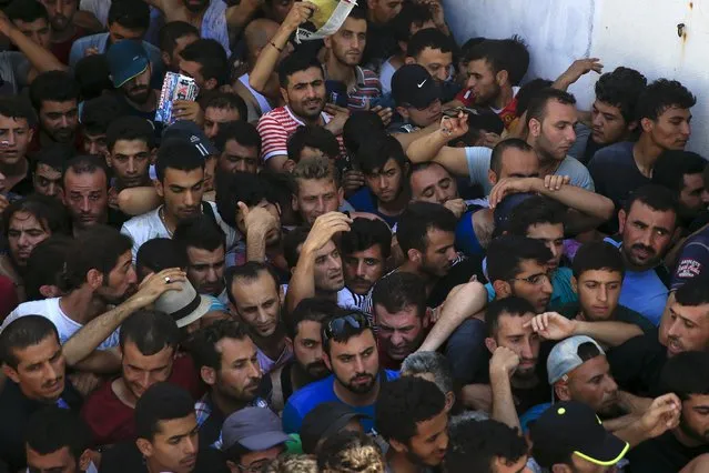Migrants and refugees are packed in a crowded line during a registration procedure at the national stadium of the Greek island of Kos, August 12, 2015. (Photo by Alkis Konstantinidis/Reuters)
