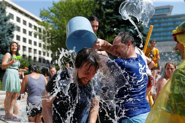 People take part in a water fight in the centre of Budapest, Hungary, June 25, 2016. (Photo by Laszlo Balogh/Reuters)