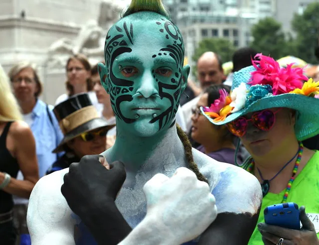 More than 25 body-painting artists from across the U.S. attempt to paint about 30 naked models during an event  at Columbus Circle July 26, 2014. After a legal battel with New York City, the event took place in the only city in the country that allows it. (Photo by Timothy A. Clary/AFP Photo)
