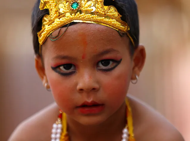 A boy dressed as Lord Krishna, a Hindu deity, participates in a parade to mark Gaijatra festival, also known as the “cow festival”, in Kathmandu, Nepal. Hindus in Kathmandu celebrate the festival to ask for salvation and peace for their departed loved ones. Cows are regarded as holy animals in Nepal which help departed souls to reach heaven. (Photo by Navesh Chitrakar/Reuters)