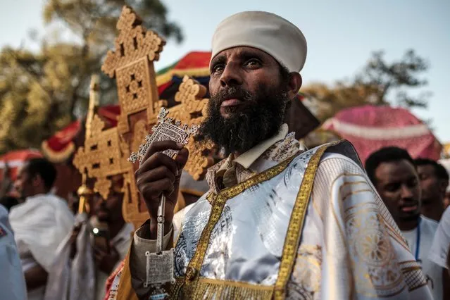 An Ethiopian Orthodox Christian priest holds a cross during the celebration of Timkat, the Ethiopian Epiphany, in Gondar, on January 19, 2020. Timkat is the Ethiopian Orthodox Christian festival which celebrates the baptism of Jesus in the Jordan river. (Photo by Eduardo Soteras/AFP Photo)