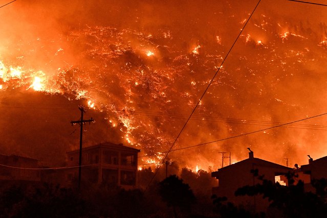 Flames rise as a wildfire burns next to the village of Ano Loutro, near Corinth, Greece, on September 29, 2024. (Photo by Vassilis Psomas/Reuters)