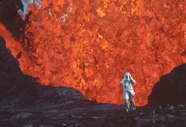 This image released by National Geographic shows Katia Krafft wearing an aluminized suit as she stands near lava burst at Krafla Volcano, Iceland, in a scene from the documentary “Fire of Love”. (Photo by National Geographic via AP Photo)