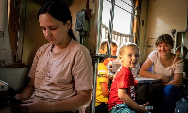 Mother Yulia (R) along with two of her children Cyrille (R2) and Lengor (R3) seen on an evacuation train to Dnipro on August 6, 2022. Amid the intensified fighting in the Eastern part of Ukraine, east Ukraine is now intensifying its civilian evacuation, as millions of Ukrainian families have been evacuating from the closer and closer war, as many of them will be relocated to the western part of the country. According to the United Nations, at least 12 million people have fled their homes since Russia's invasion of Ukraine, while seven million people are displaced inside the country. (Photo by Alex Chan Tsz Yuk/SOPA Images/Rex Features/Shutterstock)
