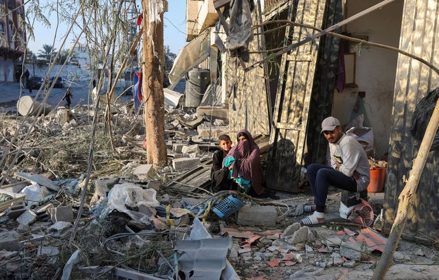Palestinians sit amid rubble at the site of an Israeli strike on a house, amid the Israel-Hamas conflict, in Nuseirat in the central Gaza Strip on December 1, 2024. (Photo by Ramadan Abed/Reuters)