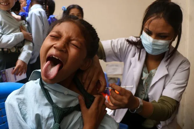 A girl receives Covid-19 vaccine as Nepal Government begins vaccinating children aged 5-12 at a school in Kathmandu on June 23, 2022. (Photo by Aryan Dhimal/ZUMA Press Wire/Rex Features/Shutterstock)