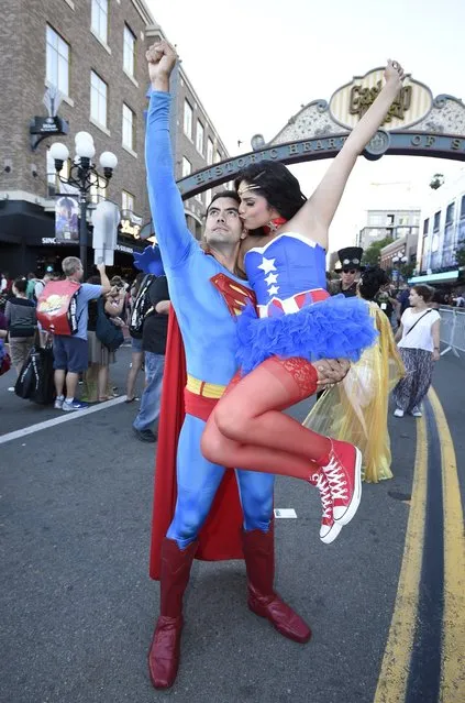 Sergio Valente, dressed as Superman, lifts Jessica Randall, dressed as Vixen, as she gives him a kiss outside of the convention center on day one of Comic-Con International held at the San Diego Convention Center Thursday, July 21, 2016 in San Diego. (Photo by Denis Poroy/Invision/AP Photo)