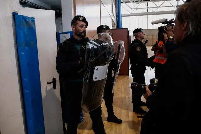 Police and gendarmerie crew intervene the voters in the Catalan independence referendum at a sport hall, where Catalan President Carles Puigdemont would be voting, in Girona, Spain on October 1, 2017. Tensions rose in some voting centers, including Saint Julia de Ramis School in Girona and Ramon Llull School in Barcelona, as dozens of anti-riot Spanish police blocked Catalan activists from voting. (Photo by Burak Akbulut/Anadolu Agency/Getty Images)