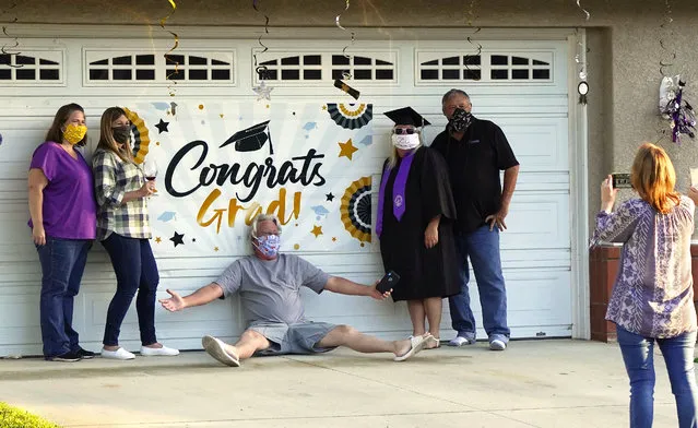 Linda White, third from right, poses with family and friends as she wears her cap and gown while celebrating graduating with a bachelor of science in elementary education and special education from Grand Canyon University during the coronavirus outbreak, Friday, May 1, 2020, in Simi Valley, Calif. White would have gone to a graduation ceremony in Arizona if not for the stay-at-home restrictions due to the coronavirus. (Photo by Mark J. Terrill/AP Photo)