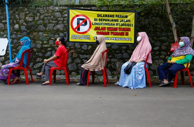 People practice social distancing while buying vegetables amid the coronavirus disease (COVID-19) outbreak in Depok, near Jakarta Indonesia, April 28, 2020. (Photo by Ajeng Dinar Ulfiana/Reuters)