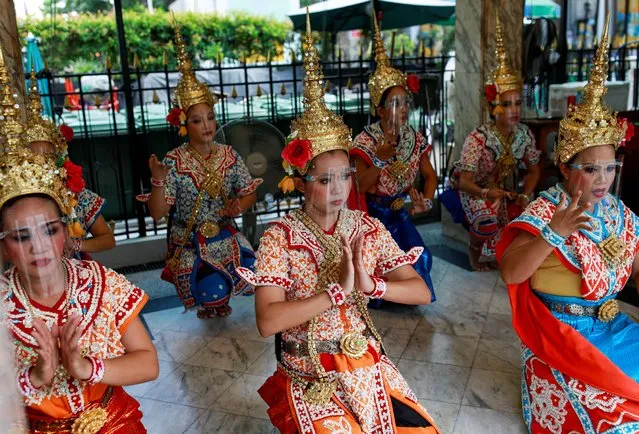 Performers wearing protective face shields perform at the Erawan Shrine, after the government started opening some restaurants outside shopping malls, parks and barbershops during the coronavirus disease (COVID-19) outbreak in Bangkok, Thailand, May 4, 2020. (Photo by Soe Zeya Tun/Reuters)