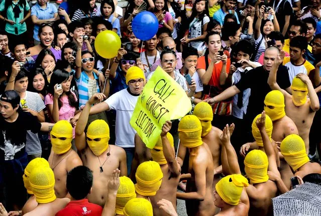 Students watch as fraternity members from the country's state university run naked around the campus to open a week-long celebration of their university's 108th foundation in Manila, Philippines, on Oktober 1, 2012. (Photo by Bullit Marquez/Associated Press)