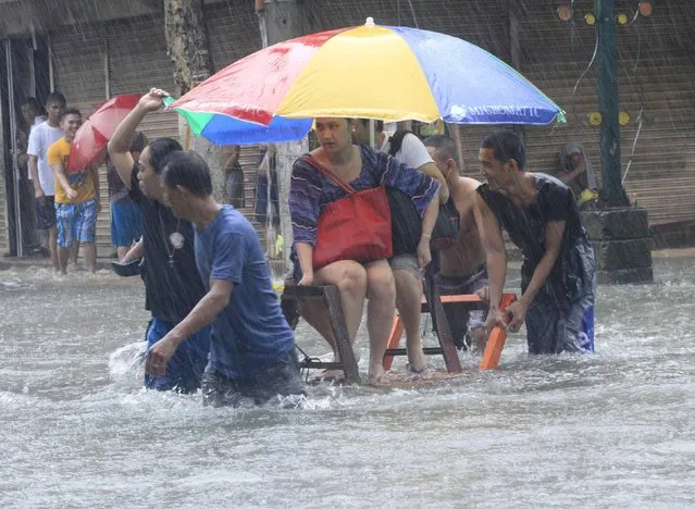 Stranded passengers ride on a improvised pushcart to cross a flooded street after tropical storm Fung-Wong battered metro Manila September 19, 2014. (Photo by Erik De Castro/Reuters)