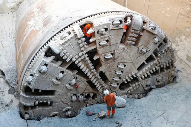 Workers tend to the tunnel boring machine which has finished digging the future west- east line of the tramway in Nice, southeastern France, on October 24, 2017. The elements of the tunnel boring machine will be demounted until december. The extension of the tramway in Nice will connect the city from West to East over a distance of 7,7 km. The line will be open to the public in 2018. (Photo by Valery Hache/AFP Photo)