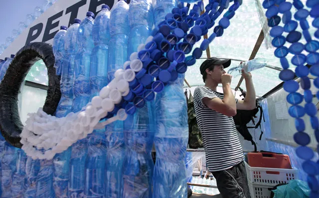 Jan Kara drinks water from a plastic bottle on his boat, made with plastic bottles, on the Elbe river near Kostelec nad Labem July 15, 2014. (Photo by David W. Cerny/Reuters)