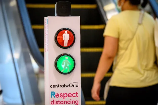 A traffic light regulates social distancing on an escalator in a shopping mall in Bangkok on June 4, 2020, as sectors of the economy reopen following restrictions to halt the spread of the COVID-19 novel coronavirus. (Photo by Mladen Antonov/AFP Photo)