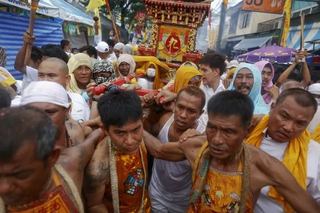 Devotees of the Chinese Bang Neow Shrine carry a religious statue back to their shrine at the end of a procession celebrating the annual vegetarian festival in Phuket September 29, 2014. (Photo by Damir Sagolj/Reuters)