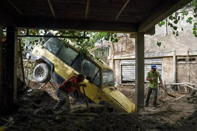 Residents remove mud inside a house after devastating floods swept through the town over the weekend, in Las Tejerias, Venezuela on October 11, 2022. (Photo by Gaby Oraa/Reuters)