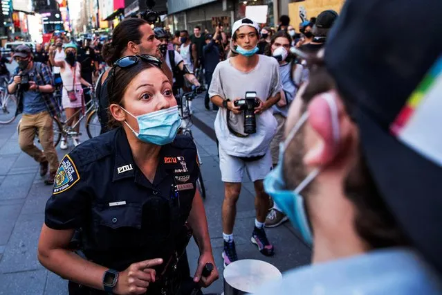 A NYPD officer argues with a demonstrator when they try to march through Times Square during a protest against racial inequality in the aftermath of the death in Minneapolis police custody of George Floyd, in New York City, New York, U.S. June 14, 2020. (Photo by Eduardo Munoz/Reuters)