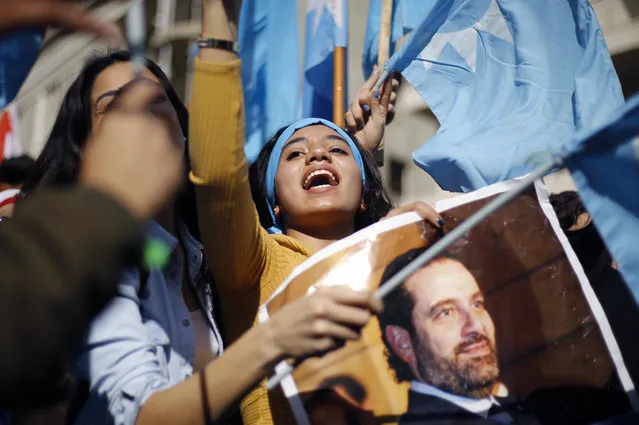 A girl chants slogans as she holds a picture of Lebanese Prime Minister Saad Hariri outside his residence in Beirut, Lebanon, Wednesday, November 22, 2017. Hariri returned to Lebanon a day earlier and in a surprise decision, said he was putting his resignation on hold responding to a request from the president to give more time to consultations. (Photo by Bilal Hussein/AP Photo)