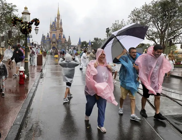 Guests brave the weather in the Magic Kingdom at Walt Disney World in Lake Buena Vista, Fla., Wednesday, November 9, 2022, as conditions deteriorate with the approach of Hurricane Nicole. (Photo by Joe Burbank/Orlando Sentinel via AP Photo)