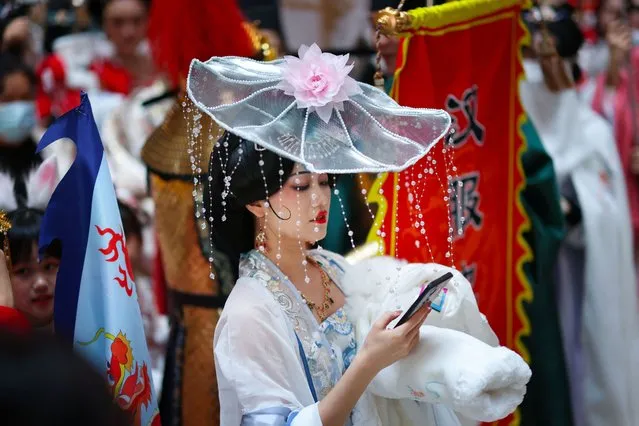 This photo taken on November 20, 2022 shows a woman wearing the Chinese transitional dress, known as Hanfu, taking part in a parade in Shenyang in China's northeastern Liaoning province. (Photo by AFP Photo/China Stringer Network)