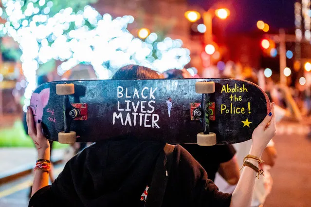 A protester with poltical messages on his skateboard marches during the Not in Our City / Not on Our Watch March in Foley Square in downtown Manhattan on July 30, 2020 in New York City. Protests erupted after the police killing of George Floyd. (Photo by Roy Rochlin/Rex Features/Shutterstock)